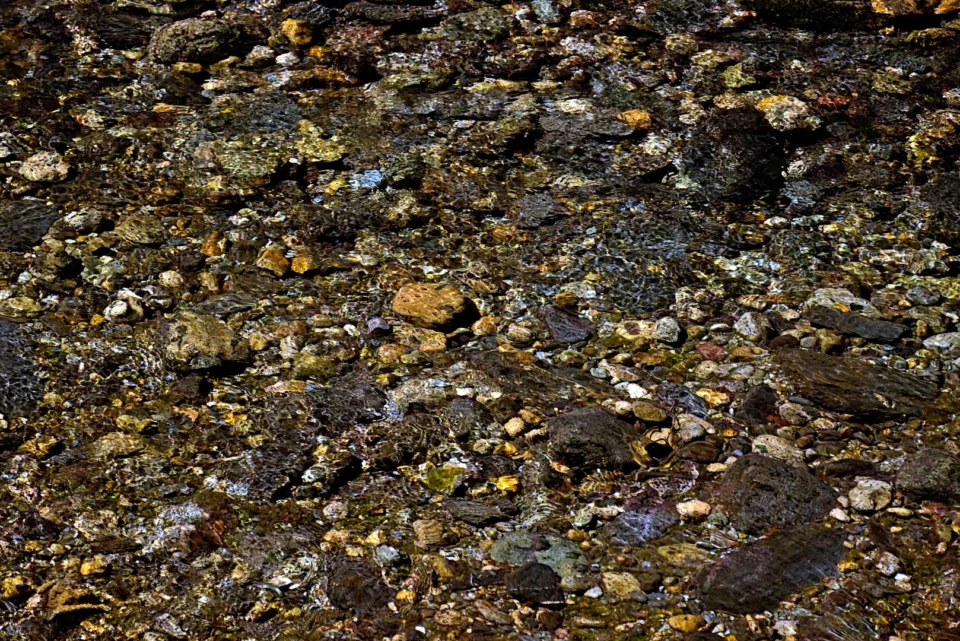 River pebbles under the crystal clear water